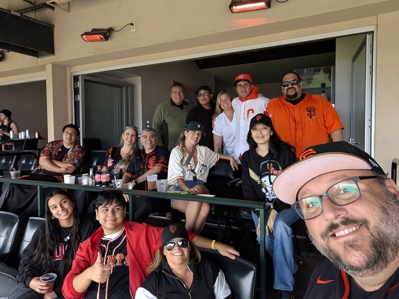 Group selfie of everyone in Giants gear inside the Bonds Suite at Oracle Park