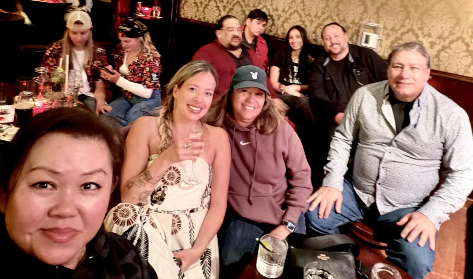 Group selfie of the gang packed into a booth at Johnny Foley's Irish House, smiling with drinks in hand