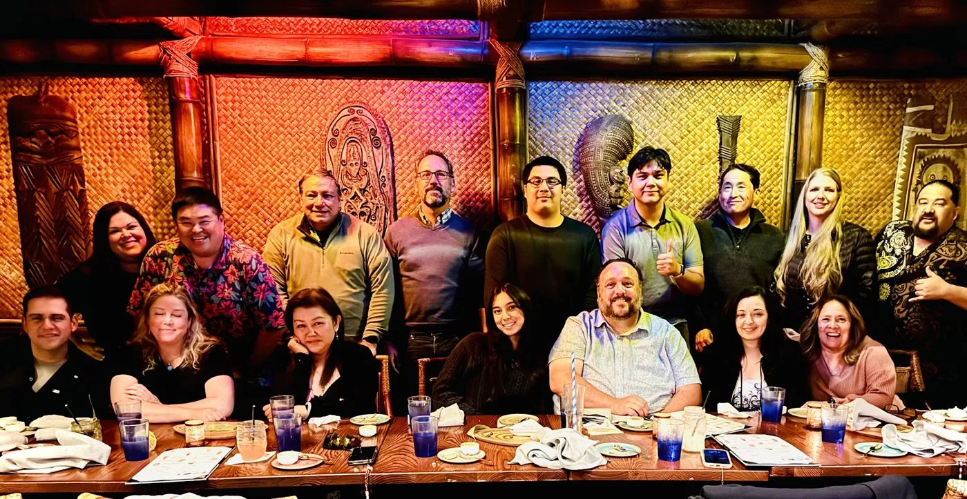 The whole group gathered around the long dinner table at the Tonga Room, lit by red and blue tiki lighting